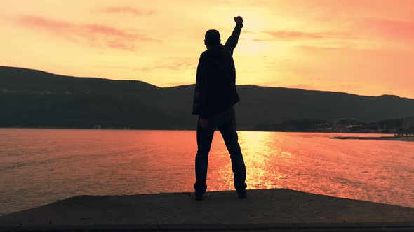 Male Celebrating Victory in the Evening at Seashore