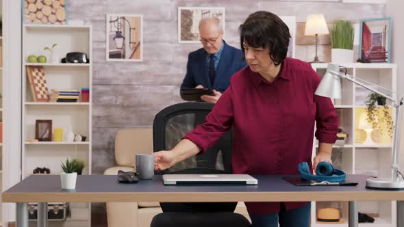 Elderly Woman Opening Laptop and Putting Glasses