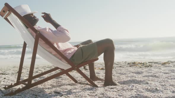 Senior african american man lying on sunbed on sunny beach