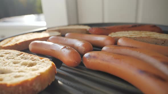 The Barbecue Grill with the Frankfurter and Toast Bread on Top