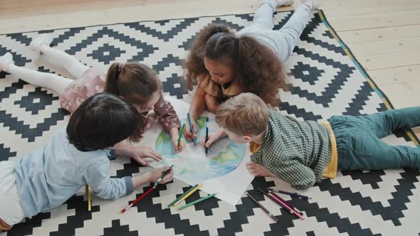 Children Lying on Rug and Coloring Picture