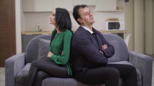 Argued Interracial Adult Couple Sitting on Couch Back to Back Talking Thinking