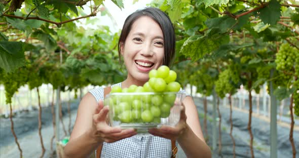 Woman holding green grape