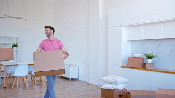 Bearded guy in t shirt looks at young woman blonde puts large cardboard box