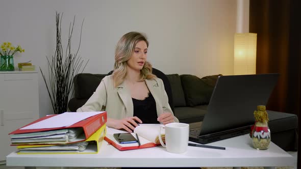 Young Caucasian woman discussing financial document with colleagues via video call