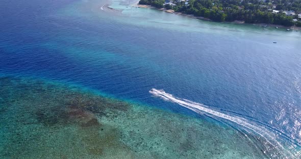 Wide birds eye copy space shot of a white paradise beach and aqua turquoise water background in 4K