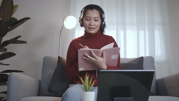 Businesswoman redshirt using a tablet with headphone for meeting online at home