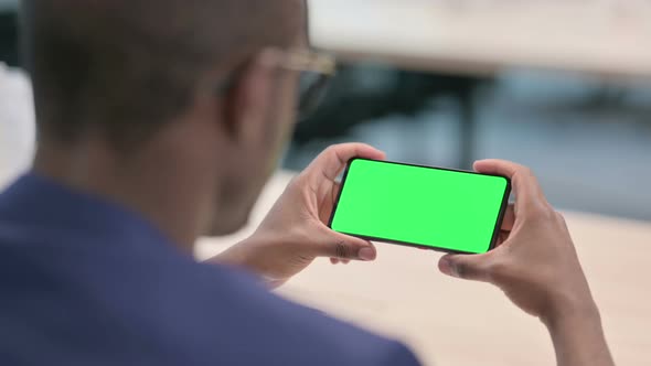 Rear View of Young Businessman Looking at Smartphone with Chroma Screen