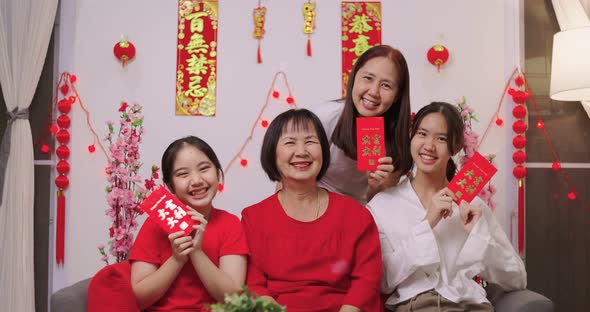 Happy Asian Multi Generations Family Celebrating Chinese New Year. Showing Lucky Red Envelope.