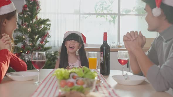 Asian little kid enjoy christmas party with parents together celebrate Xmas party at home.