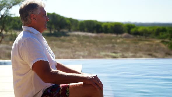 Thoughtful man sitting near pool side 4k