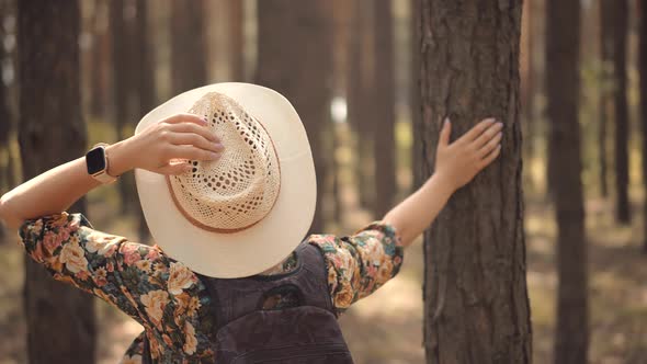 Relaxing Woman In Hat Walking Pine Forest. Girl In Dress Walking In Greenwood.
