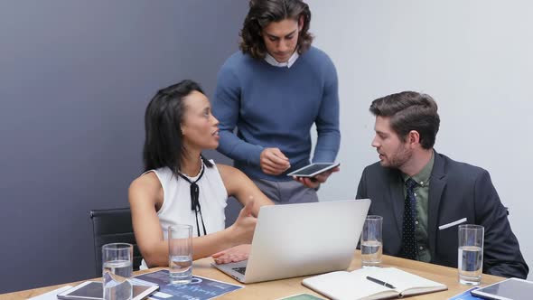 Group of executives discussing over laptop at desk 4k