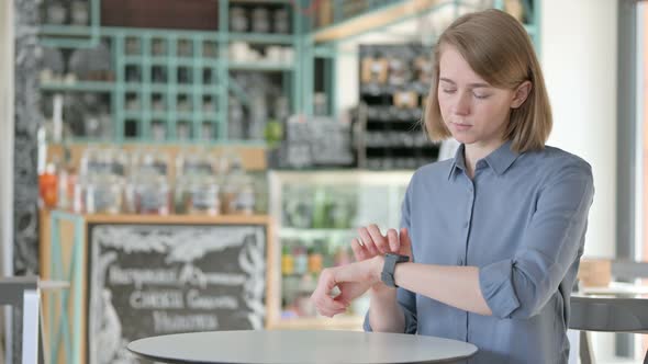 Young Woman Using Smartwatch in Cafe