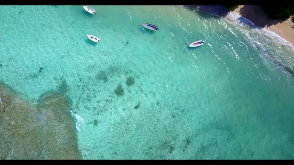 Aerial top down landscape of perfect island beach vacation by blue green lagoon with clean sand back
