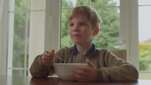 Cute Blonde Kid Eating Soup Sitting Alone at Home