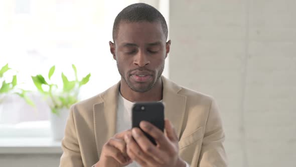 Portrait of African Man Reacting to Loss on Smartphone