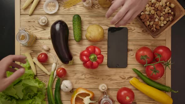 Human's Hands Putting Vegetables From Wooden Table Simultaneously