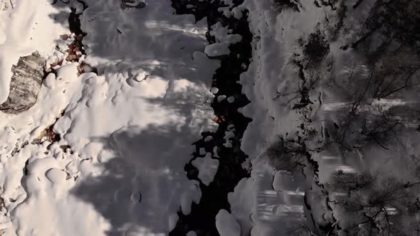 Aerial Top View Over Snowcovered Coast Mountain River Stream