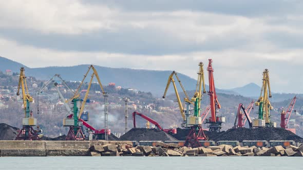 The cranes are loading bulk materials and coal in the seaport.