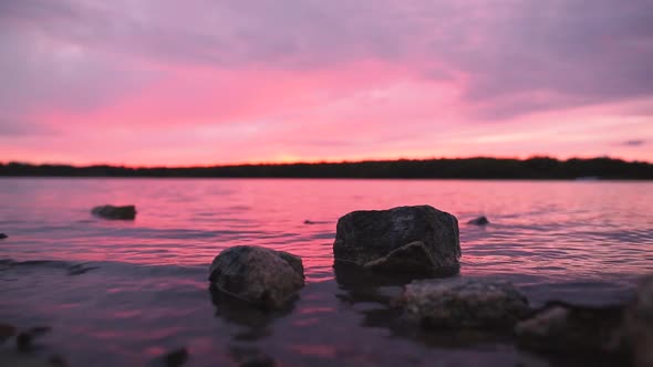 Big Rocks In Lake at Orange and Pink Sunset