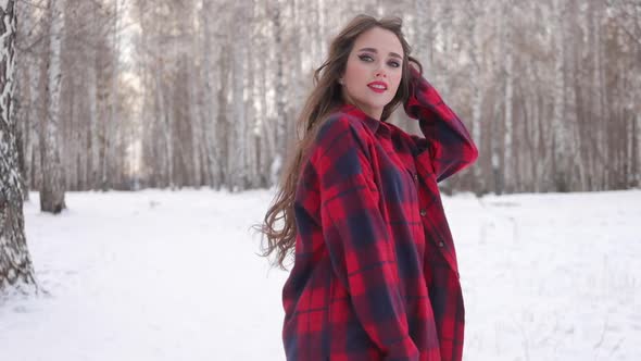 Female in Checkered Shirt Walking in Snowy Park