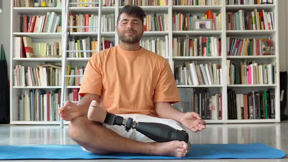 Disabled Man with Prosthetic Leg Prosthesis Meditating Doing Yoga at Home