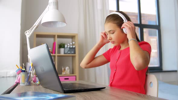 Girl in Headphones with Laptop Computer at Home