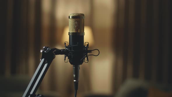 Studio Microphone And Pop Shield On Mic Stand With Yellow Light On Background