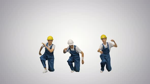 Three Young Construction Workers in Hard Hats Synch Dancing Looking at Camera on Gradient Background