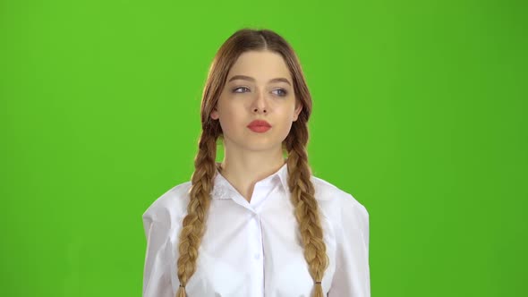 Student in a White Blouse and Pigtails Shows a Fis. Green Screen