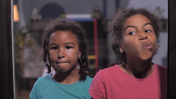 Funny Mixed Race Girls Grimacing at Home Window