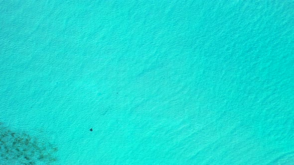 Daytime above travel shot of a white sand paradise beach and blue ocean background in hi res 4K
