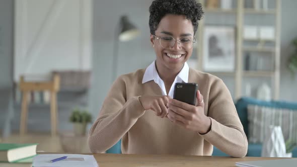 Cheerful African Girl Using Her Smart Phone