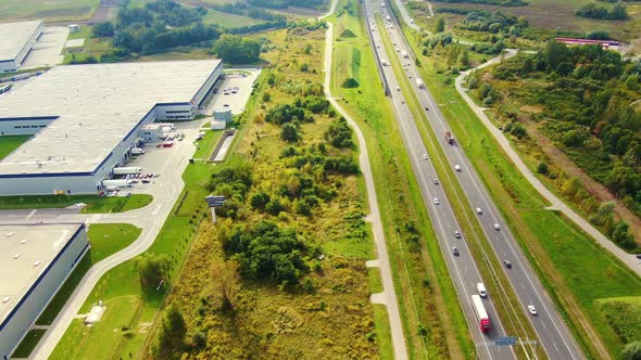 Big logistics terminal in countryside near highway, Delivery center traffic on the highway aerial sh