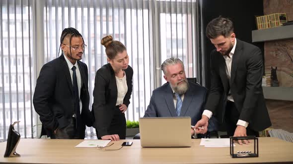 Solid mature man, the director of the company talks to his employees in office