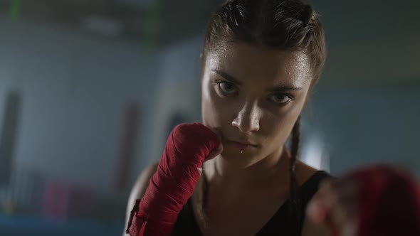 Woman Power Portrait of a Female Fighter Stands in a Combat Stance and Looks Into the Camera a