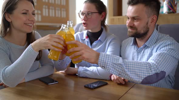 Three Friends Sit in a Cafe Drink Juice and Have Fun Communicating