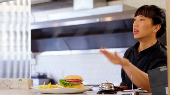 Waitress ringing order bell at counter 4k