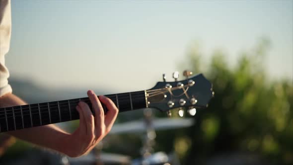 Close Up Shot of a Man's Hands, Who Plays the Rhythm Guitar with a Mediator