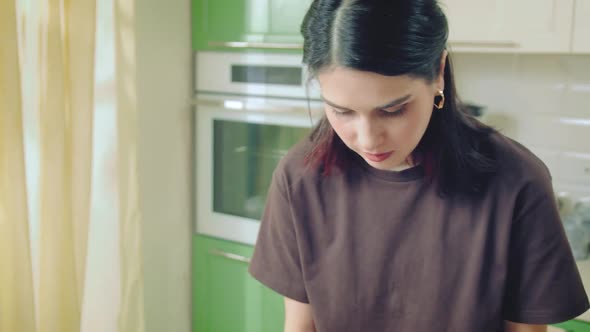 Young Caucasian Woman in Brown Tshirt Cooking at Home Kitchen