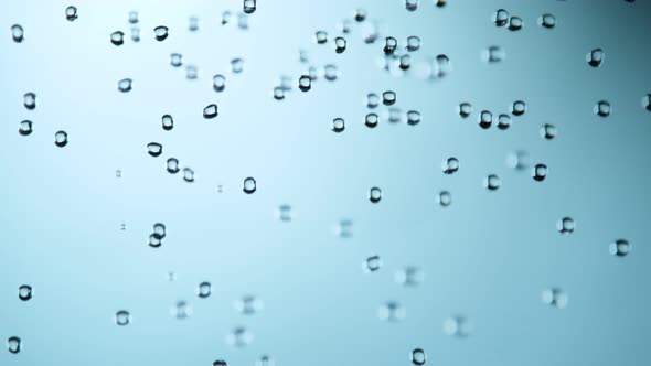 Super Slow Motion Shot of Various Water Drops Falling on Light Blue Background at 1000Fps