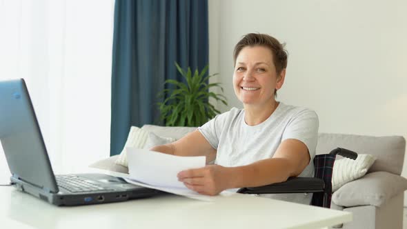 Portrait of Senior Woman Freelancer in Wheelchair with Laptop at Home