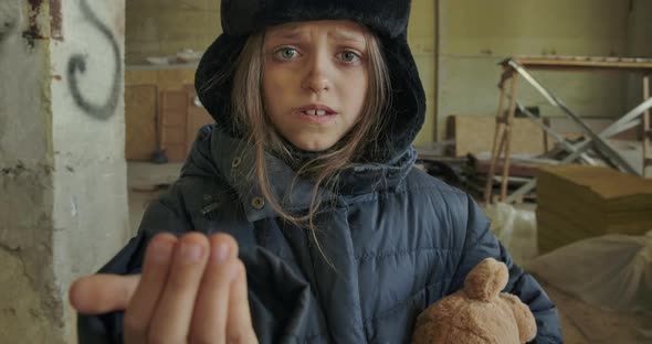 Little Ukrainian Refugee in Dirty Winter Clothes Asking for a Handout