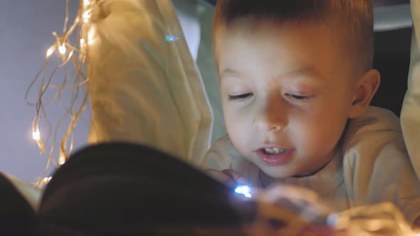 Happy Family Little Boy Holding Flashlight in a Wigwam Play at Night