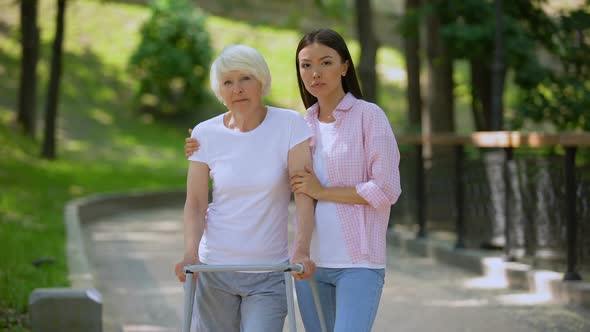 Sad Aged Patient Walking Frame and Daughter Looking Camera, Social Insecurity