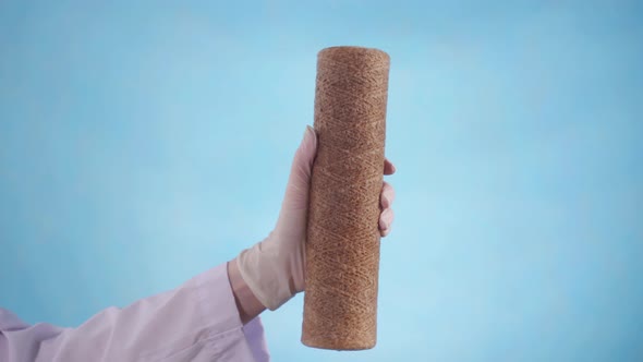 Woman's Hand in a Robe and Gloves Holds a Used Water Filter Cartridge