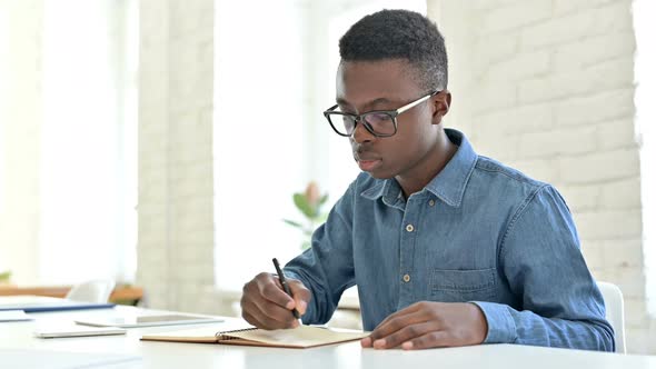 Serious Young African Man doing Paperwork