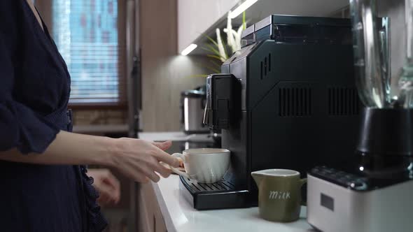 Girl Prepares Morning Coffee in a Coffee Machine