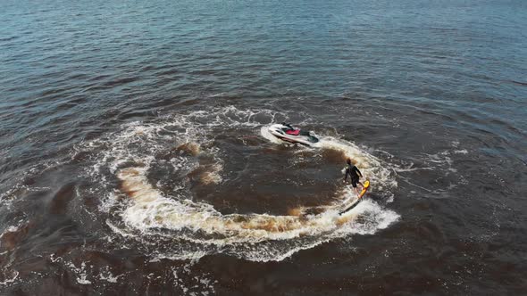 A Man Flying Around Over the Water on the Flyboard in Circles  Aerial View